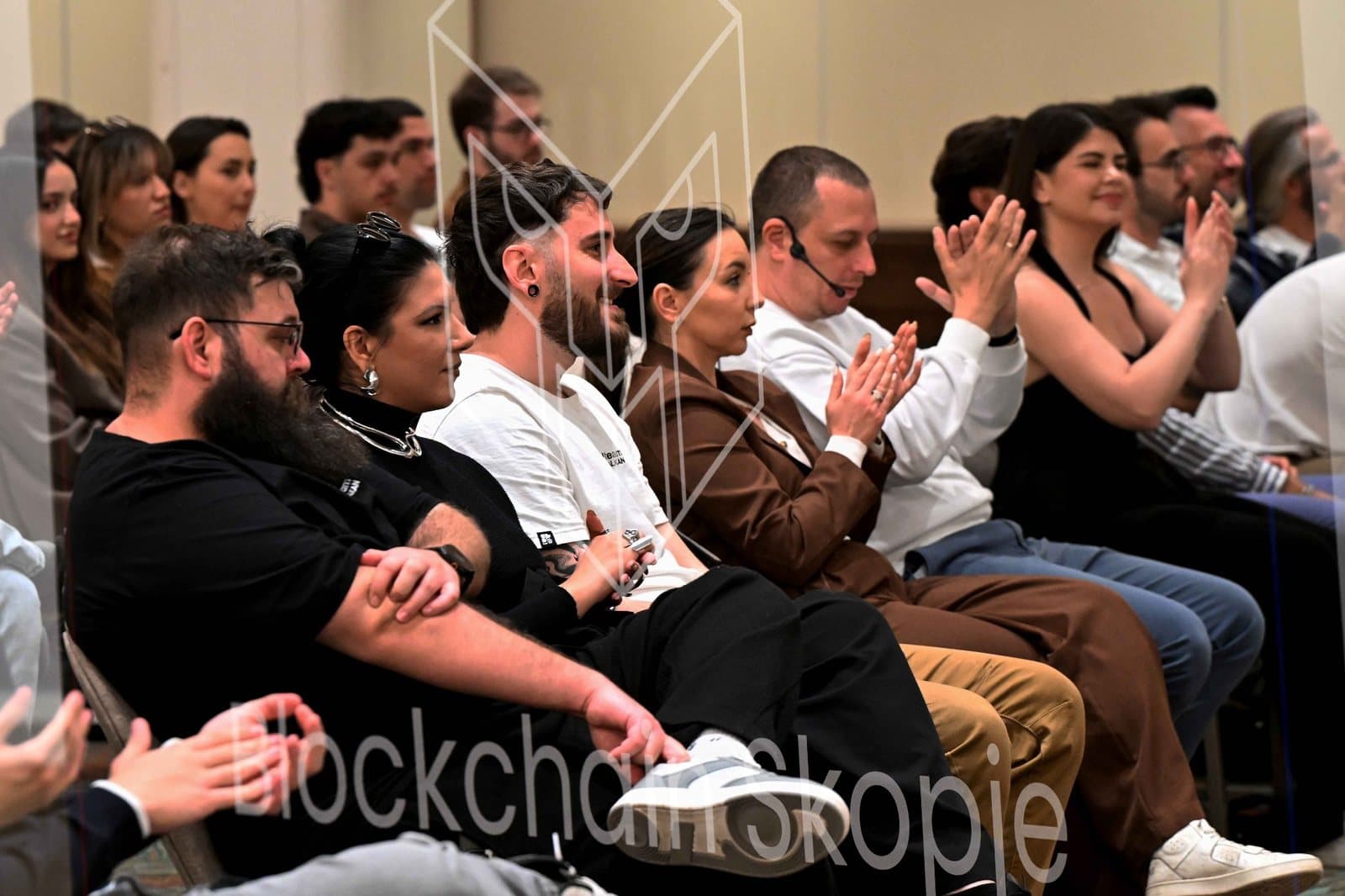 A panel on stage at the Summit in front of a full room.